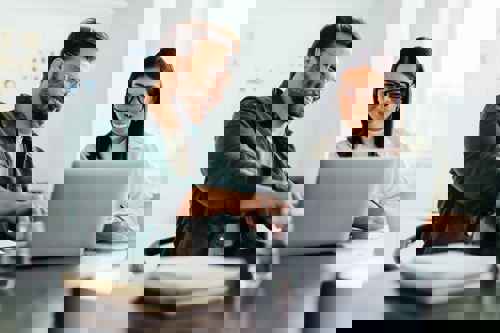 Woman with Health Insurance for Abroad on Laptop at Work